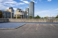 a parking lot that has an empty space with a skate board in it with many buildings behind it