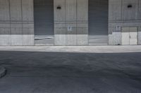 a skate board is in the middle of an empty parking lot outside a building with shutters to allow in some space