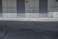 a skate board is in the middle of an empty parking lot outside a building with shutters to allow in some space