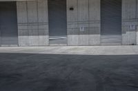 a skate board is in the middle of an empty parking lot outside a building with shutters to allow in some space