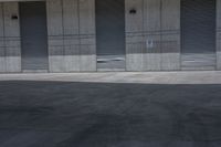 a skate board is in the middle of an empty parking lot outside a building with shutters to allow in some space