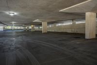 a person skateboards in an empty parking lot under some lights and lamps on them