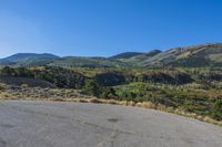 empty parking lot in front of steep mountain area on clear sunny day with blue sky