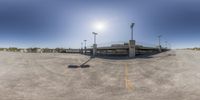 a view through a fish eye lens on an empty parking lot and street lights near a bridge