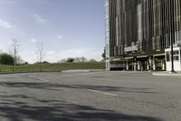 an empty parking lot is shown in the middle of a cityscape with grass, trees and skyscraper