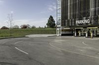 an empty parking lot is shown in the middle of a cityscape with grass, trees and skyscraper