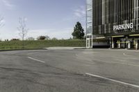 an empty parking lot is shown in the middle of a cityscape with grass, trees and skyscraper