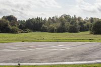 an empty parking lot with an airport in the background and birds nearby to the right