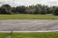 an empty parking lot with an airport in the background and birds nearby to the right