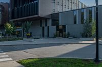 an empty parking lot near a large building with some windows on the side of it