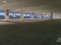 a empty parking lot with three white trains on it's tracks in a building