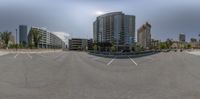 a panorama lens shot of an empty parking lot in an urban area with some buildings around