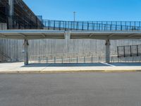 an empty parking lot is in front of the building with stairs and a ramp leading up to the sidewalk