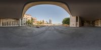 a view looking from an empty parking lot into the city in the distance, and a brick wall is visible behind it