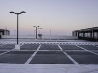 an empty parking lot with no cars parked on it's side and the sky in the background