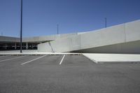 a cement wall has been modified to create a diagonal tunnel between two parking spaces at an empty parking lot