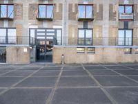 an empty parking lot next to some brick building with many windows and balconies