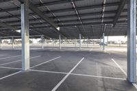 empty parking lot with many large open roofing areas and poles sticking into the ground