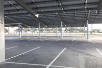 empty parking lot with many large open roofing areas and poles sticking into the ground