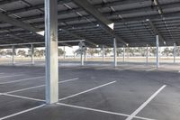 empty parking lot with many large open roofing areas and poles sticking into the ground