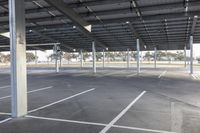 empty parking lot with many large open roofing areas and poles sticking into the ground