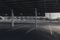 empty parking lot with many large open roofing areas and poles sticking into the ground