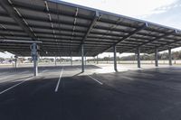 empty parking lot with many large open roofing areas and poles sticking into the ground