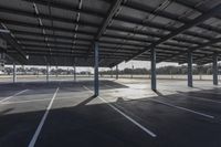 empty parking lot with many large open roofing areas and poles sticking into the ground