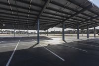 empty parking lot with many large open roofing areas and poles sticking into the ground