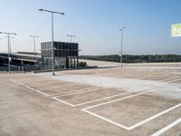 an empty parking lot has signs indicating parking spots and lines on the ground for parking