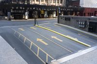 an empty parking lot with yellow arrows painted on the street side of it's curb