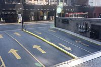 an empty parking lot with yellow arrows painted on the street side of it's curb