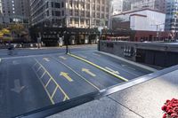 an empty parking lot with yellow arrows painted on the street side of it's curb