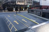 an empty parking lot with yellow arrows painted on the street side of it's curb