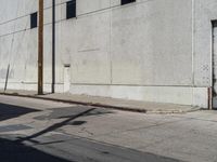 the parking meter is empty near the side of the building on the sidewalk beside the street