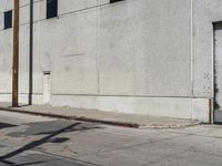 the parking meter is empty near the side of the building on the sidewalk beside the street