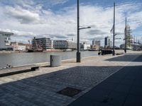 an empty parking space and sidewalk on the beach near some tall buildings in the distance