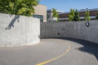 an empty parking space with yellow lines and no cars on it in the background, and building with concrete walls