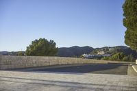 empty parking space near mountain area, with large building in background and mountains in distance