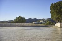 empty parking space near mountain area, with large building in background and mountains in distance