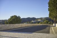 empty parking space near mountain area, with large building in background and mountains in distance