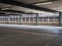 a empty parking space next to some windows in a building with a balcony area overlooking the train tracks
