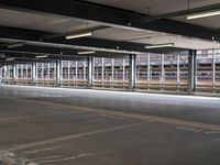 a empty parking space next to some windows in a building with a balcony area overlooking the train tracks