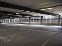 a empty parking space next to some windows in a building with a balcony area overlooking the train tracks