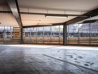 a empty parking space next to some windows in a building with a balcony area overlooking the train tracks