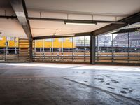 a empty parking space next to some windows in a building with a balcony area overlooking the train tracks