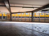 a empty parking space next to some windows in a building with a balcony area overlooking the train tracks