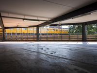 a empty parking space next to some windows in a building with a balcony area overlooking the train tracks