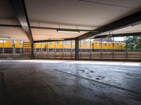 a empty parking space next to some windows in a building with a balcony area overlooking the train tracks