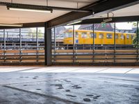 a empty parking space next to some windows in a building with a balcony area overlooking the train tracks
